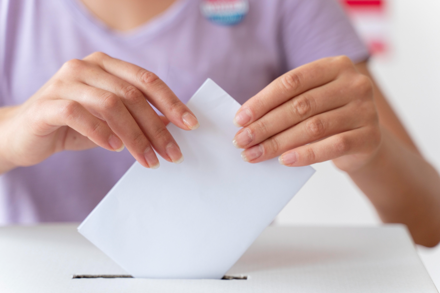 Persona introduciendo su voto en urna.